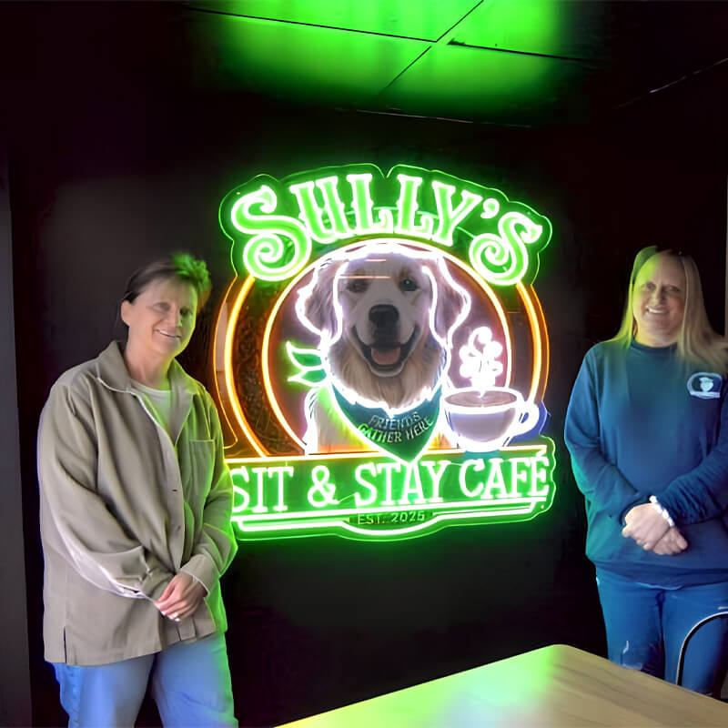 Two people standing in front of a neon sign for 'Sully's Bit & Stay Cafe' with a dog illustration.