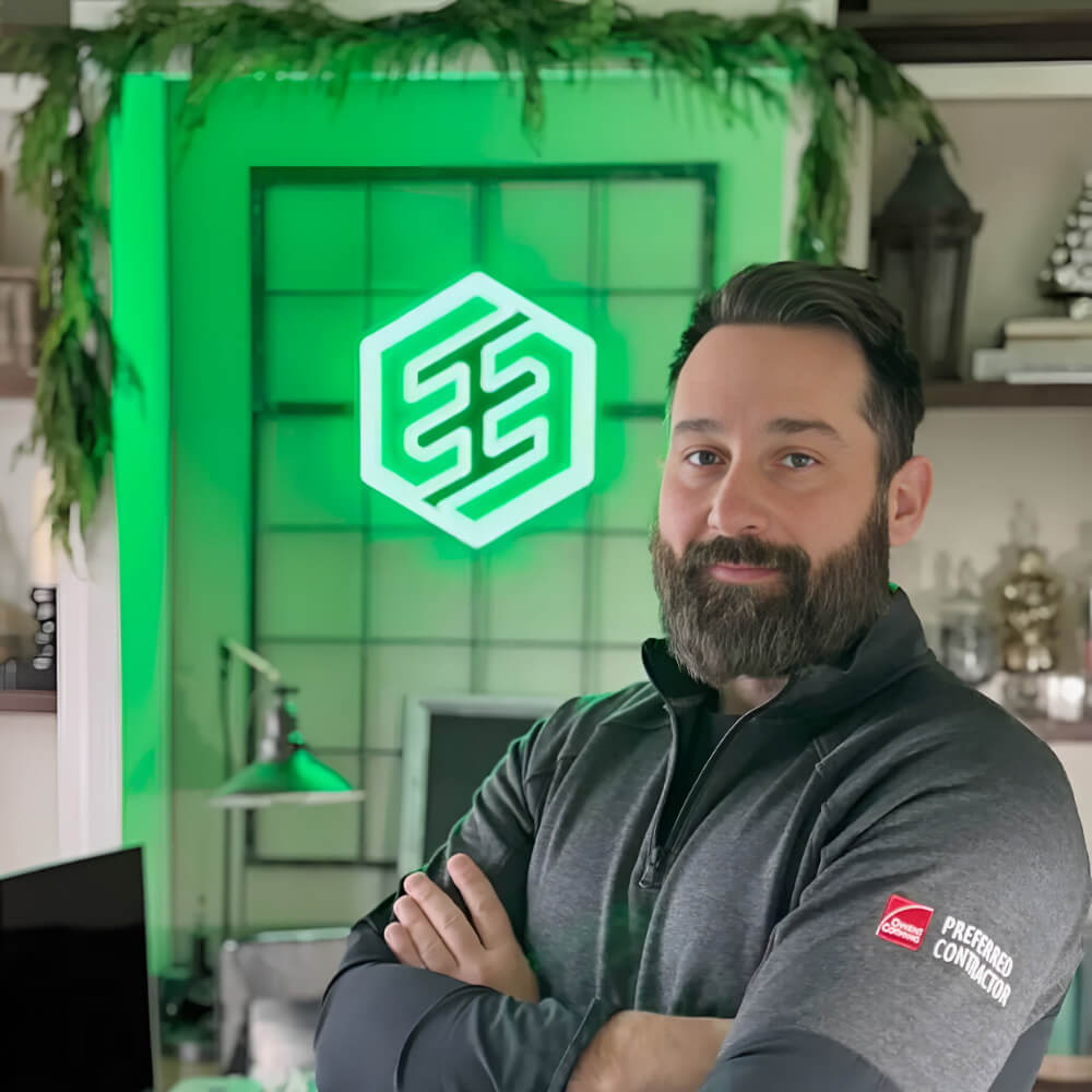 Exterior Echelon owner standing in a room with a green logo neon sign on the wall.