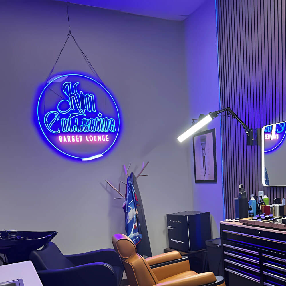 Neon sign for 'Kin Exclusive Barber Lounge' in a barbershop setting with chairs and tools.